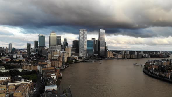 Aerial view of storm dark clouds over Canary Wharf skyscrapers at sunset