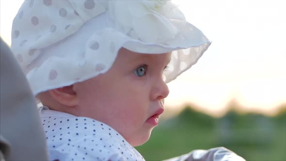 Slow Motion Close-Up Shot of Five Months Baby Girl Sitting Outdoors in a Stroller