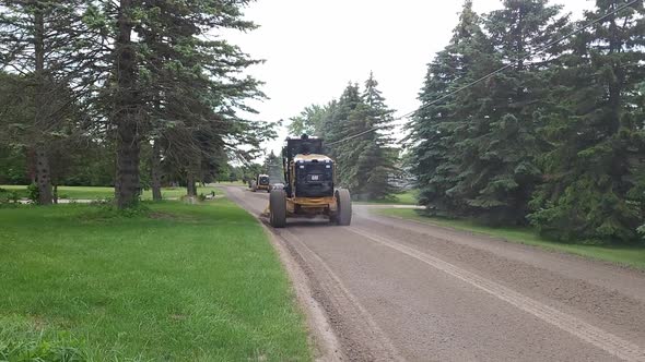 Graders Grading Dirt Road In South East Michigan. wide shot