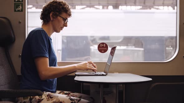 Woman in Glasses Working on a Laptop While Waiting for the Train Departure