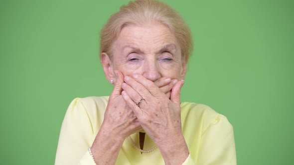 Beautiful Senior Businesswoman Covering Mouth As Three Wise Monkeys Concept