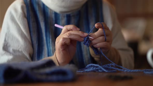 A woman knitting a neck warmer