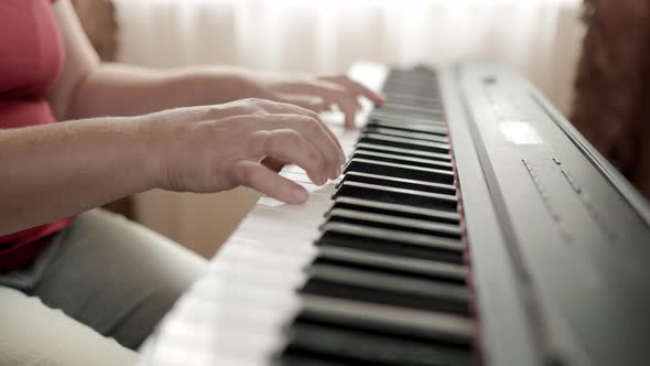 Close up of woman's hand playing on the electric piano. Female synthesizer player.