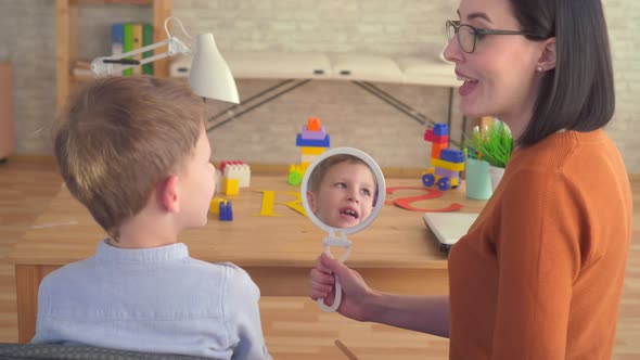 Close Up of a Preschooler Looking in the Mirror and Engaged with a Speech Therapist