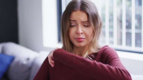 Woman sneezing on her elbow