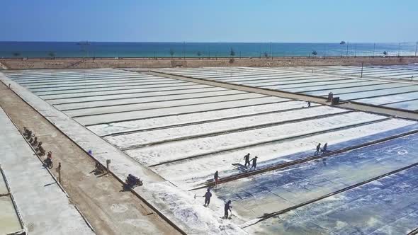 People Work on Salt Plantations Against Azure Ocean