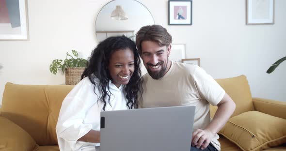 Happy Young Multiethnic Couple Making a Video Call Showing a Pregnancy Test