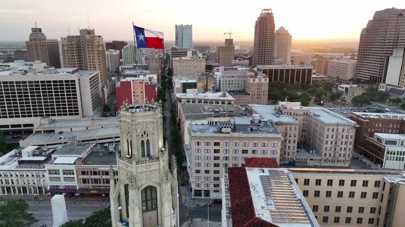 Texas flag proudly flies above Downtown San Antonio TX. Aerial at sunset reveals beautiful skyline.