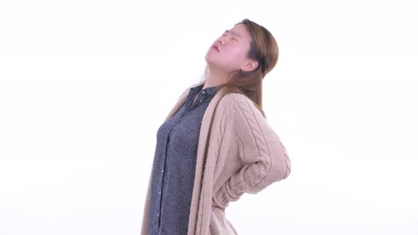 Stressed Young Asian Woman Having Back Pain in Winter