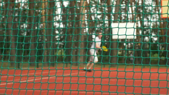 Active Sporty Man Playing Tennis on Outdoor Court