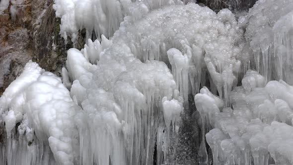 Waterfall Flowing Behind Ice Wall