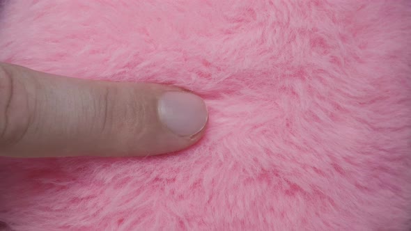 Finger slides over pink fur