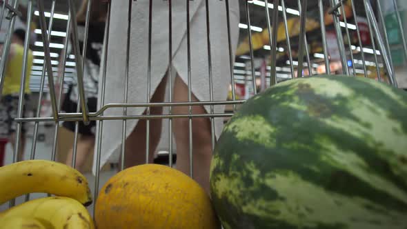 Woman Putting Fruits in Shopping Cart in Market