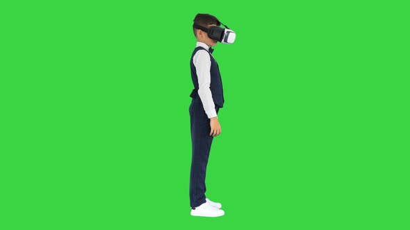 Boy in Formal Wear Playing the Game in Virtual Reality Goggles on a Green Screen Chroma Key