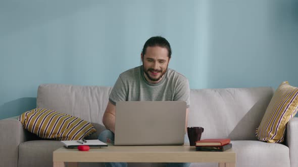 Man Is Sitting on Sofa and Communicating Online