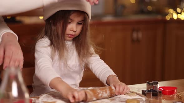 Daughter and Mom Using Rolling Pin for Making Gingerbread