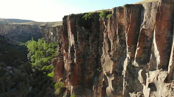 Aerial Deep Long Rift Canyon with Cleft Steep Rock Walls and High Cliff Gorge