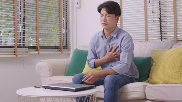 Asian man suffered a heart attack, resulting in chest pain and illness on the sofa.