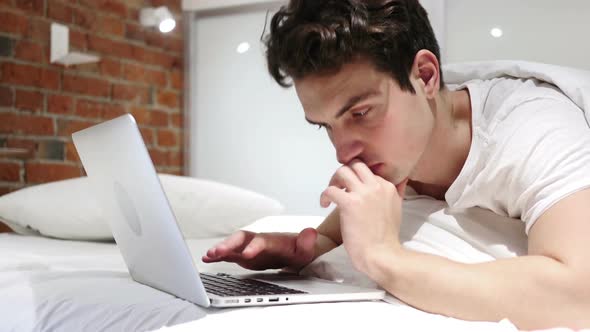Man Working on Laptop Lying in Bed for Rest