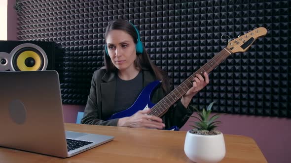 Female Learning Play Guitar at Home Using Online Lessons