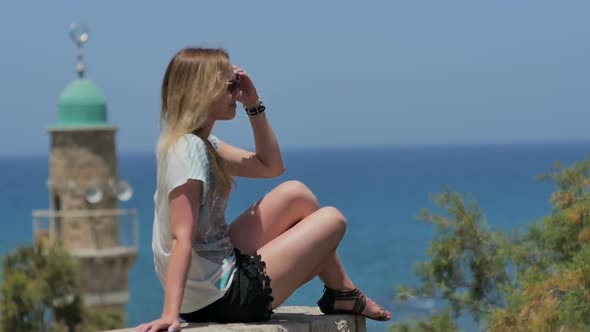 Young Woman in Sunglasses Enjoying the Sun and Sea View