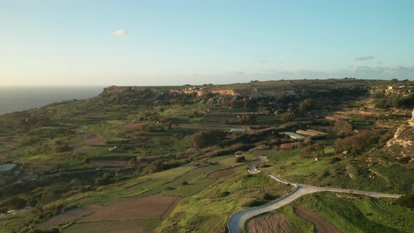 AERIAL: Green Farmlands Rugged with Roads and Rocky Surface near Mediterranean Sea