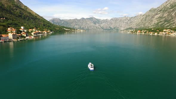 Small Fishing Boat in a Mountainous Bay Rising Aerial