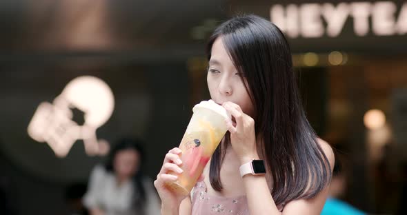 Woman drink of iced take away tea at outdoor shop