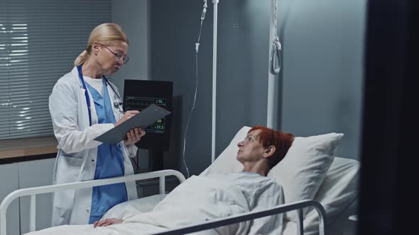 Doctor Interviewing Woman in Hospital Ward