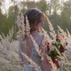 A Young Woman Dressed in a Gray Wedding Dress. She Has Flowers in Her Hand and Is in the Park - VideoHive Item for Sale
