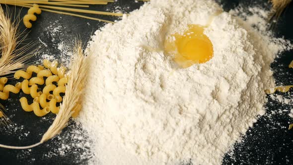 Egg Falling on a Bunch of Flour for making a Dough for Homemade Pasta