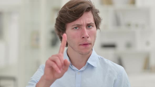 Casual Young Man Saying No with Finger Sign