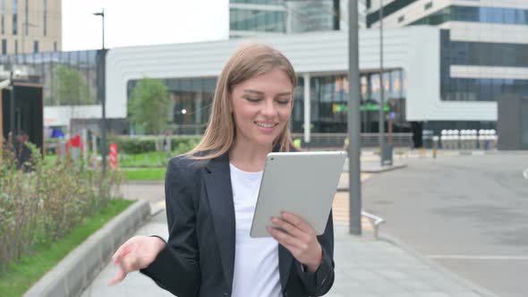 Young Businesswoman Talking on Video Call on Tablet While Walking on the Street