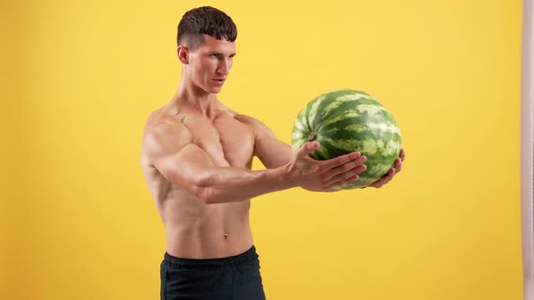 Athlete Sportsman Lifting Heavy Watermelon for Triceps Muscles on Yellow Backdrop Aspiration