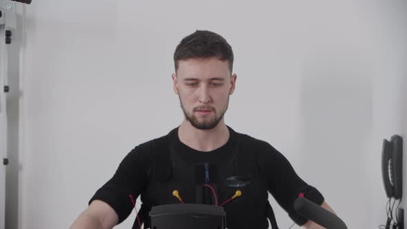 A Man in Electric Stimulation Suit Working Out in the Local Gym