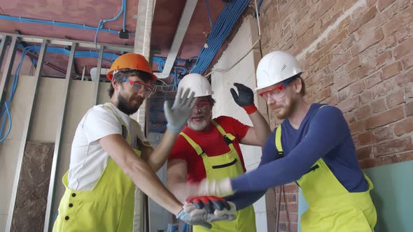 Team of Builders Standing with Hands Clasped Together