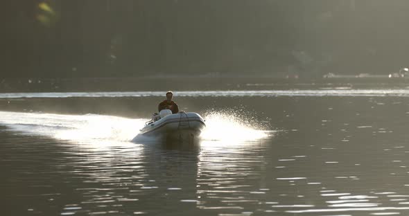 Male in Motorboat Moving at Water of Alaskan Bay on Summer Evening With Sunlight as Backlight, Slow