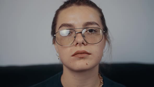 Portrait of a Redhaired Young Woman Freckled with Glasses and Caught Hair Looking to One Side Then