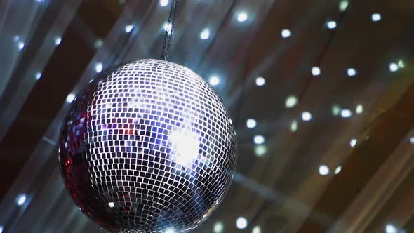 Mirror ball spinning slowly and shimmering. Round silver ball on the background with moving spots. S