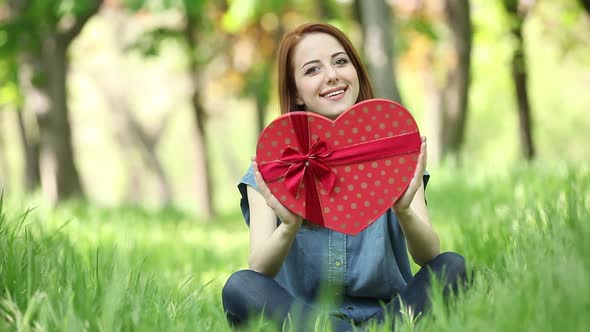 Young girl hold red heart shape gift box