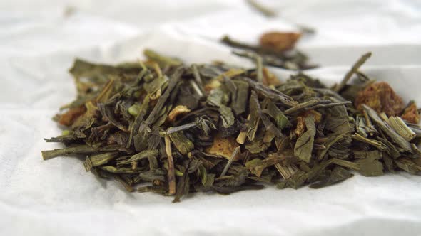 Dried green leaves of herbal tea with hemp on a white paper napkin