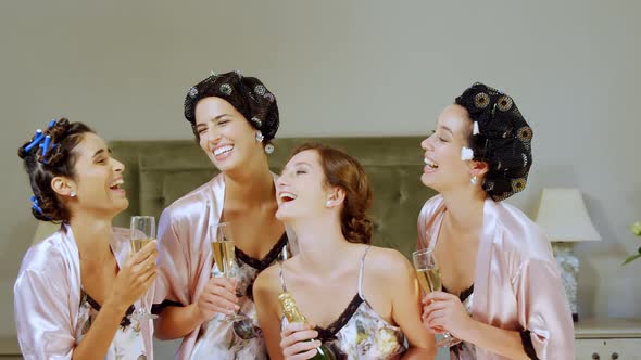 Four happy bridesmaids in nightdress having a glass of champagne 4K 4k