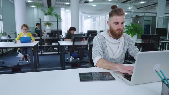 Hipster Businessman Doing Company Analytics in Office