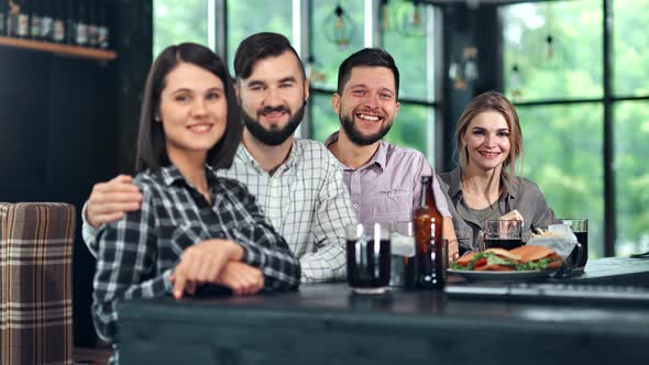 Adorable Young People Smiling Posing Looking at Camera During Informal Meeting at Pub