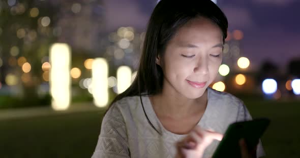 Woman Surfing Online on Cellphone at Night 
