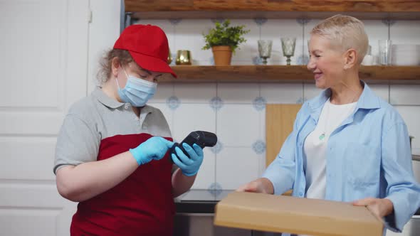 Senior Woman Ordering Pizza and Playing with Credit Card at Home