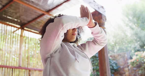 African american woman practicing yoga and meditating at vacation home