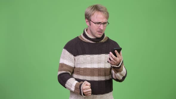 Studio Shot of Stressed Man Using Phone and Getting Angry