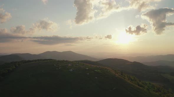 Aerial parallax of campers on top of mountain watching sunrise in Appalachians