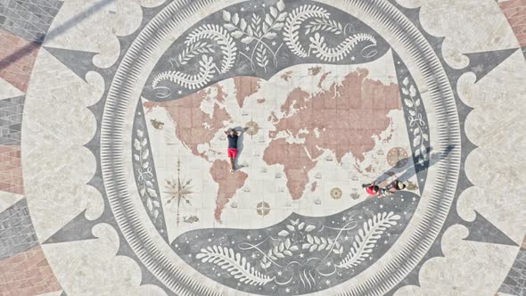 Drone Footage of a Man Laying on the Mosaic Forming a World Map